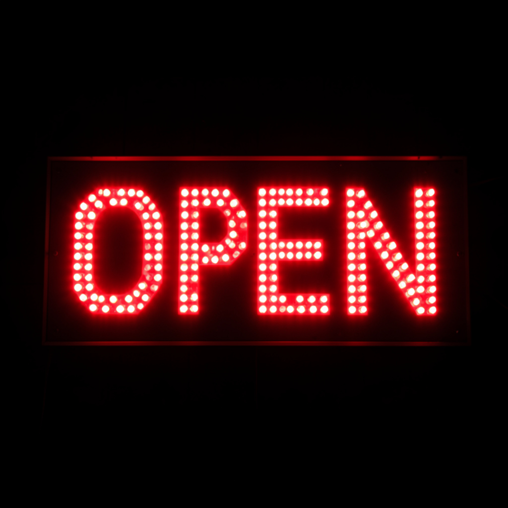 The word 'OPEN' displayed on a red LED sign with glowing pix