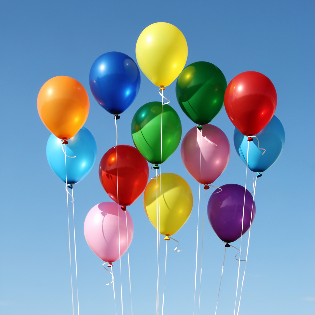 Exactly 11 colorful balloons floating against a clear blue s