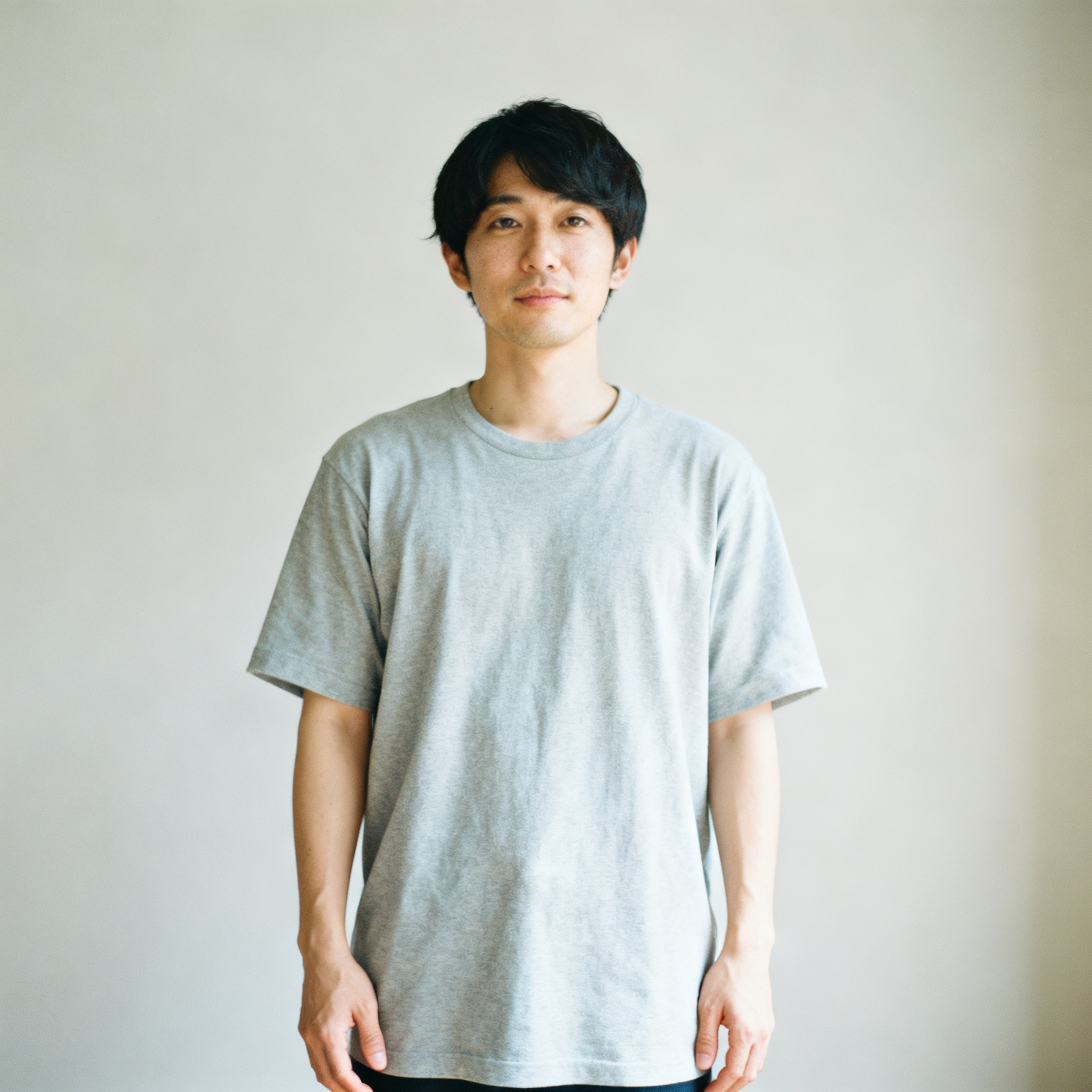 A person standing with both hands visible at their sides, fi