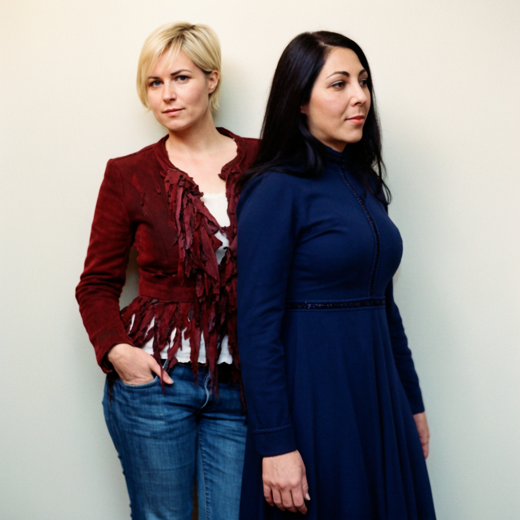 Two women standing side by side: one with short blonde hair 