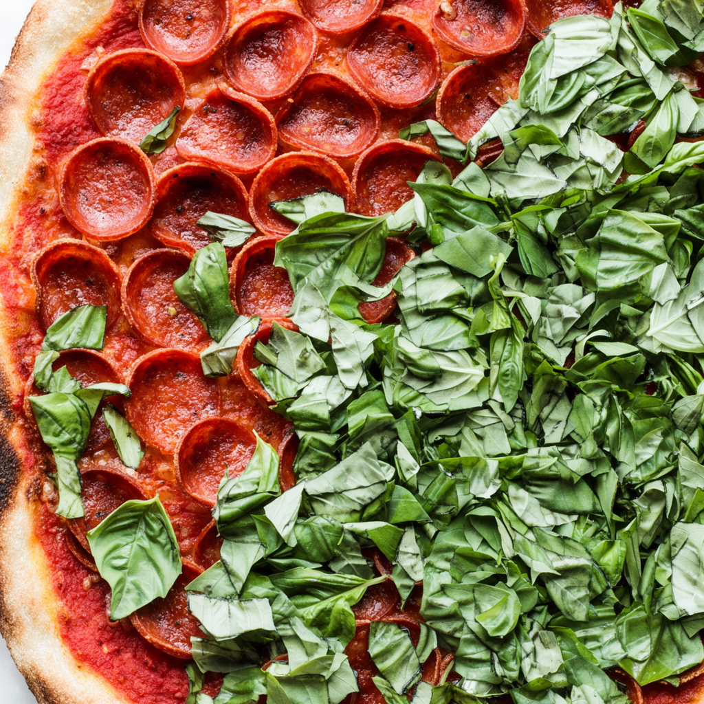 A pepperoni pizza with tomato sauce, basil, and crust but ab