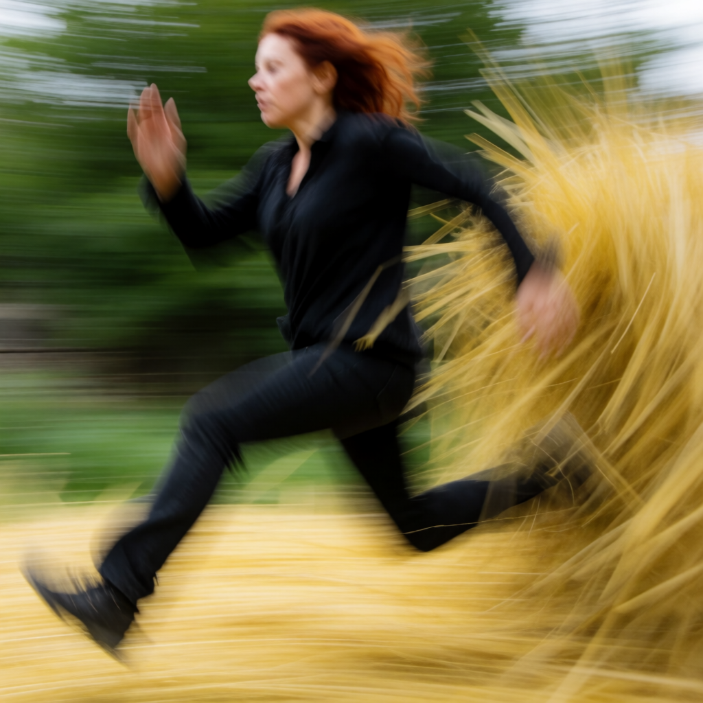 A woman mid-stride running through a park, hair and clothes 