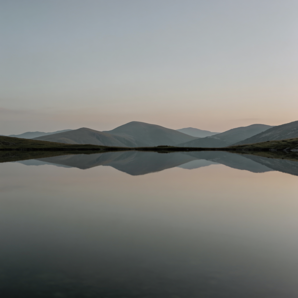 A mountain range reflected in a still alpine lake, with the 