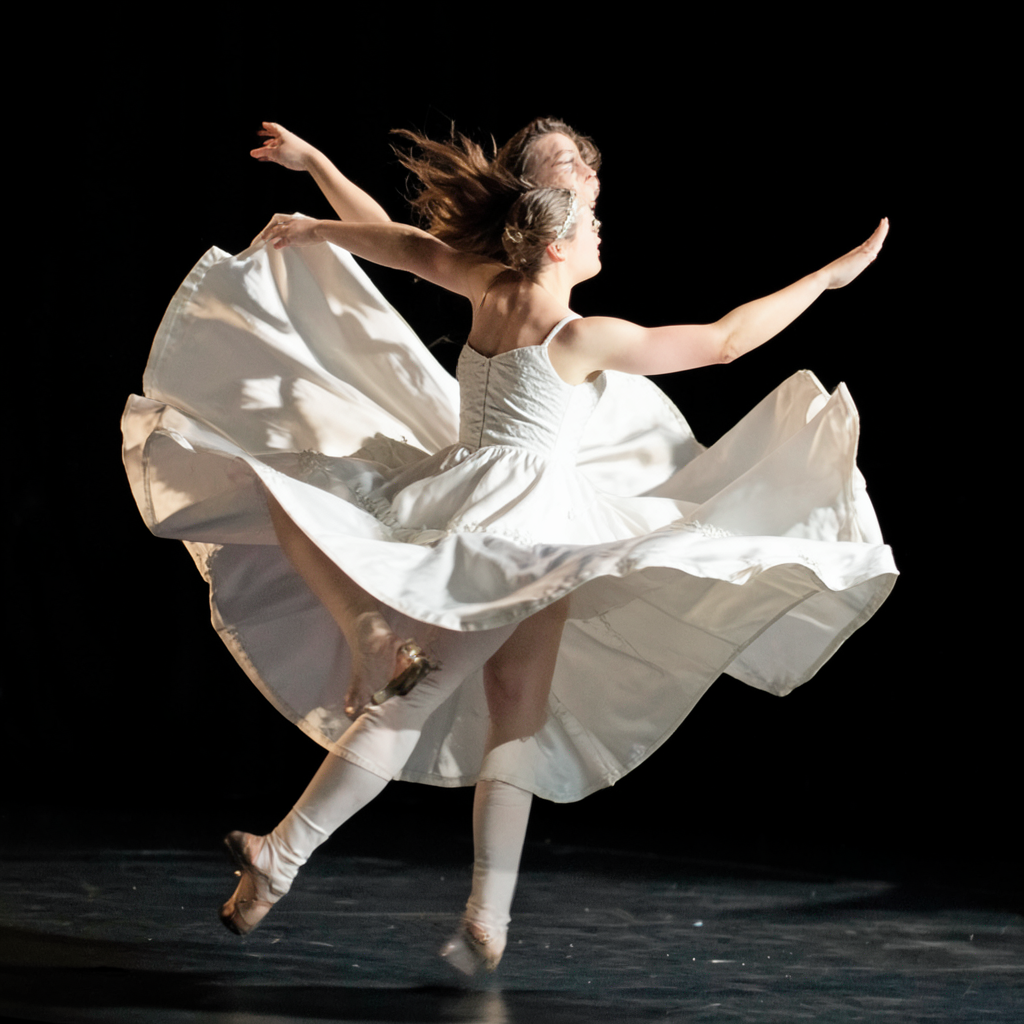 A dancer in a dynamic spin, dress flowing outward with one l