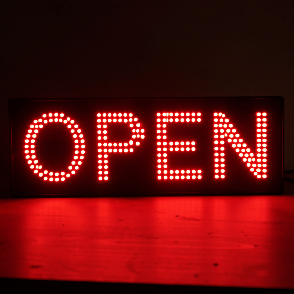 The word 'OPEN' displayed on a red LED sign with glowing pix