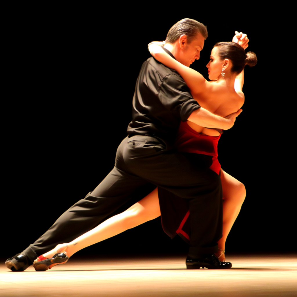 Two tango dancers in a close embrace, the man dipping the wo