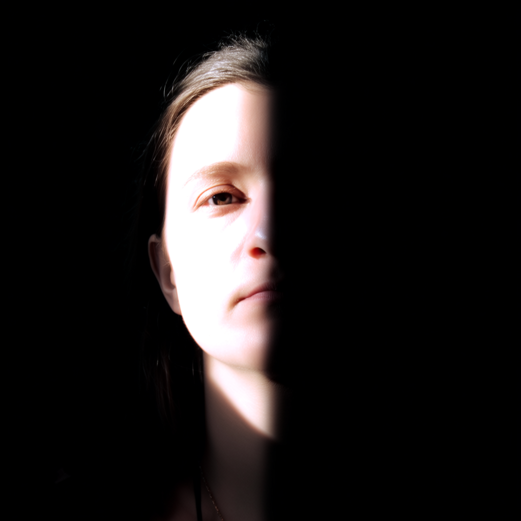 A portrait with dramatic split lighting — half the face brig
