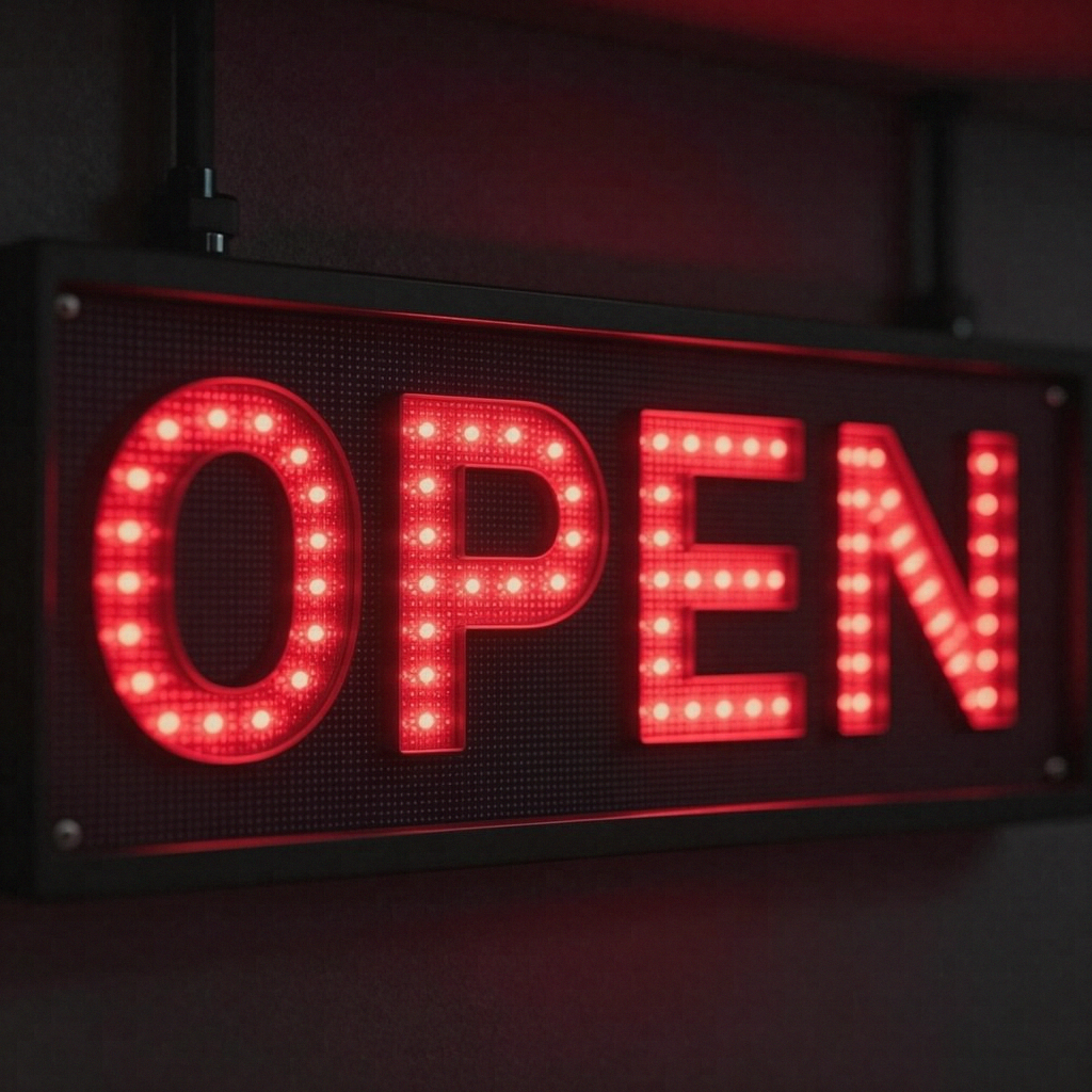 The word 'OPEN' displayed on a red LED sign with glowing pix