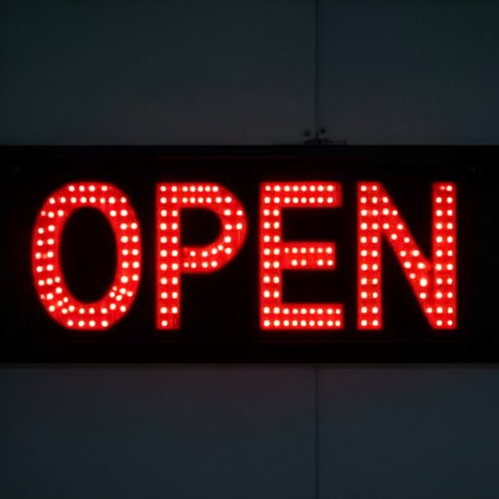 The word 'OPEN' displayed on a red LED sign with glowing pix