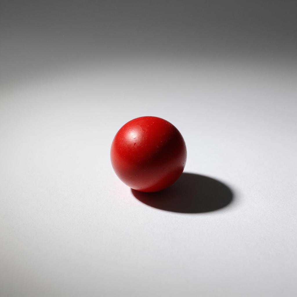 A red sphere on a white surface with a single shadow cast to